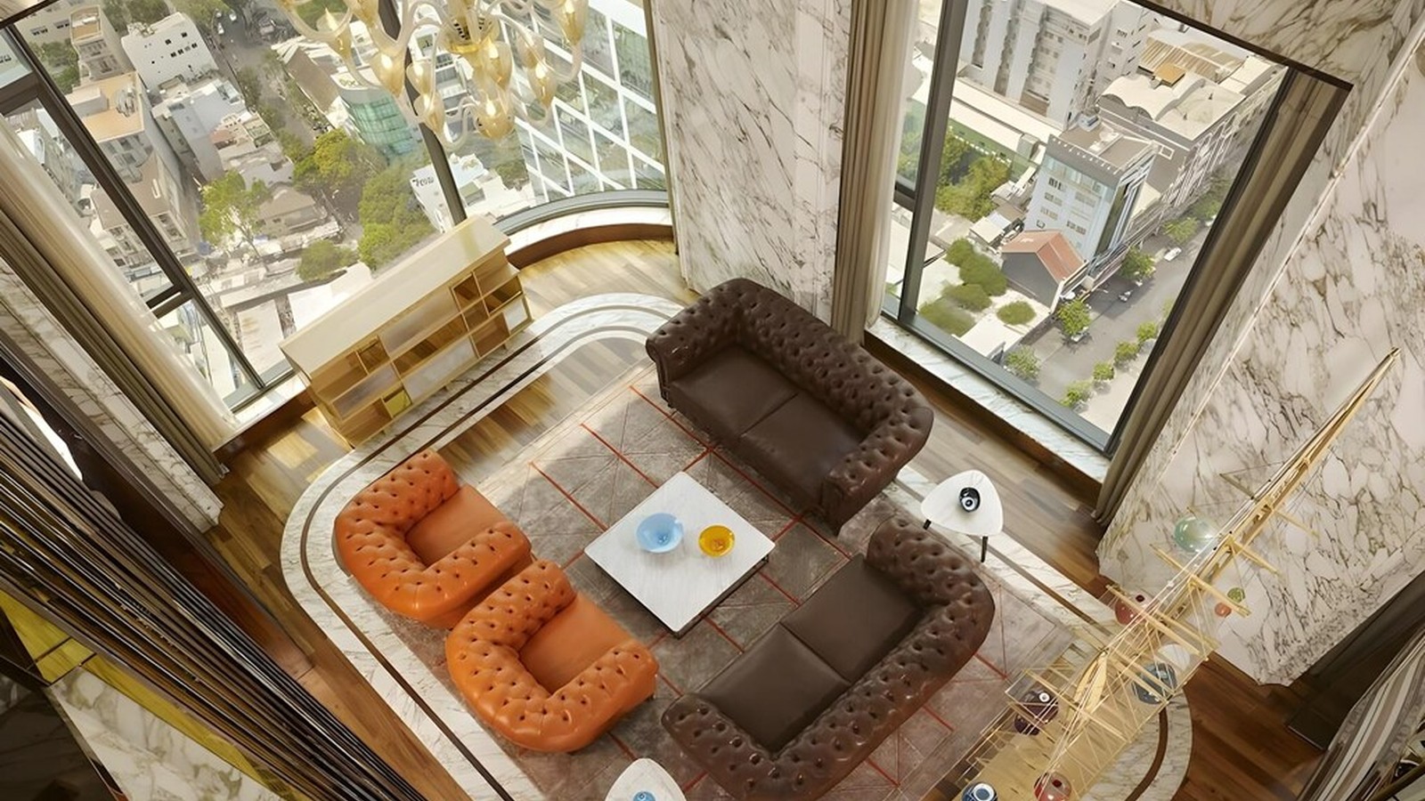 Phòng khách thông tầng kết hợp tường đá, cửa kính lớn và sofa da chần nút.