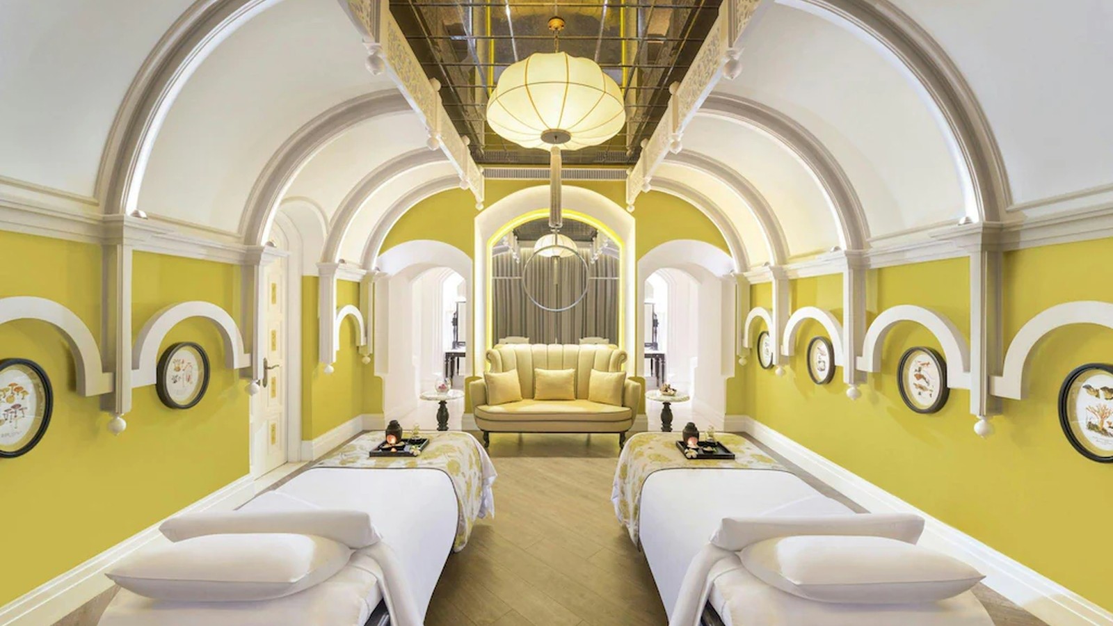 Phòng spa dùng mái vòm, sắc vàng nhẹ và bố cục đôi để tạo trạng thái thư giãn.